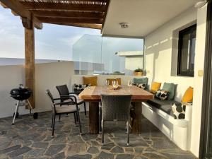 a dining room with a wooden table and chairs at Daidas Beach House - with hot whirlpool in Famara in Famara