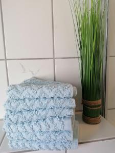 une pile de serviettes sur une table à côté d'un vase dans l'établissement Ferienwohnung Schwalbennest, à Niebüll