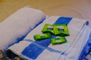 two green containers sitting on top of a towel at Cabana Raízes - LaCabanasEco in Chapecó