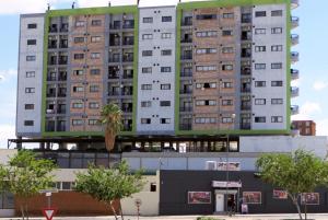 a tall building with a palm tree in front of it at Platinum Heights Merensky in Windhoek