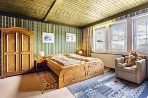 a bedroom with a bed and a chair and windows at Haus Sonnenberg in Willingen