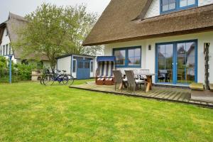 a house with a deck with a table and chairs at Ferienhaus Seepferdchen in Dranske