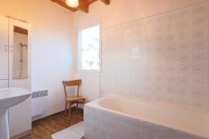 a bathroom with a tub and a sink and a chair at Maison pêcheur vue mer in Pleubian +23 photos
