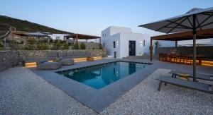a swimming pool in a backyard with a house at ANOTERRA VILLAS -Auralis in Ambelas