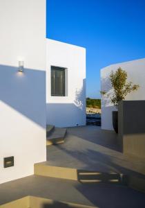 a white building with a potted plant in the middle at ANOTERRA VILLAS -Auralis in Ambelas