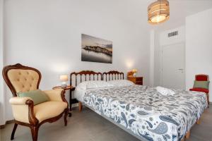 une chambre avec un lit et une chaise dans l'établissement Segesta Charming Home, à Sestri Levante