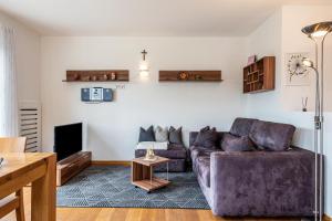 a living room with a couch and a tv at Apartement Santner in Siusi