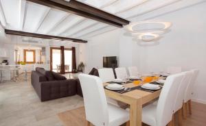uma sala de jantar com uma mesa e cadeiras brancas em Casa Sant Sebastia em Pollença