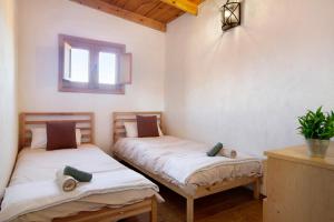two twin beds in a room with a window at Casa Rural Los Colorados in Vega de San Mateo