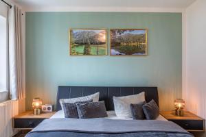 une chambre avec un lit avec trois tableaux au mur dans l'établissement Ferienwohnung Tannenblick 2-1, à Oberhof