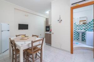 una cucina e una sala da pranzo con tavolo e sedie di Brezza Marina Marzamemi a Marzamemi