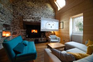 a living room with a stone fireplace and a tv at Villa 7pers piscine-spa plage 4kms in Peumérit