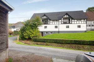 ein großes weißes Haus mit einem schwarzen Dach in der Unterkunft Ferienwohnungen Übern Hof in Schmallenberg