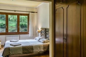 een slaapkamer met een bed en een raam bij Can Blau in Vallfogona de Ripolles +25 foto's