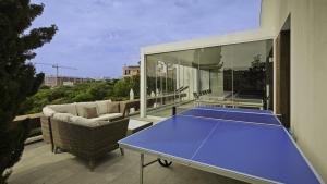 une table de ping-pong sur un balcon avec un court de tennis dans l'établissement Sweet Home Albufeira, à Albufeira