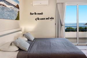 a bedroom with a bed with a view of the ocean at Ninho Gaivota in Porto Moniz