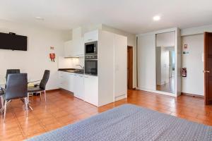 a living room with a kitchen and a table and chairs at Ninho Gaivota in Porto Moniz +13 photos