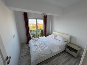 ein weißes Schlafzimmer mit einem Bett und einem Fenster in der Unterkunft Staywell University with underground parking in Suceava