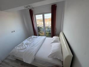 ein weißes Bett in einem Zimmer mit Fenster in der Unterkunft Staywell University with underground parking in Suceava