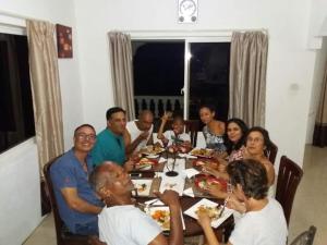 
a large group of people sitting around a dinner table at Precious Residence C in Grand'Anse
