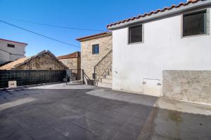 an empty parking lot next to a white building at Casaesquerda Cinza in Vieira do Minho