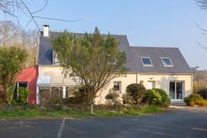 a large white house with a red roof at Grande maison à 5min des plages in Pouldreuzic
