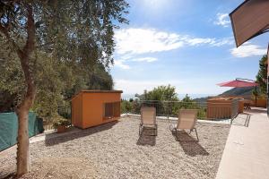 een patio met 2 stoelen en een boom bij La Colombera in Alassio