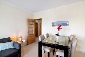 a living room with a table and a couch at Lovely one bedroom apartment in Quarteira