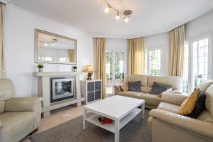 Una sala de estar con muebles blancos y chimenea. en Casa Isabella luxury villa, en Nerja