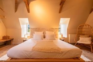 une chambre avec un grand lit et deux chaises dans l'établissement Château des Salettes, à Anoye