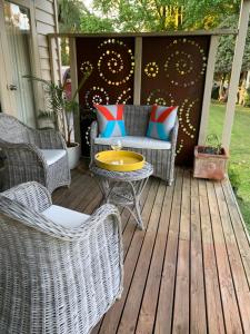 a patio with wicker chairs and a table on a deck at A Bed & A Red @ Berry’s Creek in Berrys Creek