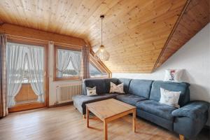 a living room with a blue couch and a table at Haus Kandelblick in Furtwangen +43 photos