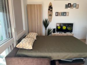 a bed in a room with a couch and a tv at Sunset Studio in Alvor