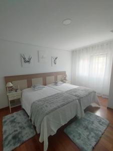 a bedroom with a large bed with two rugs at O Son in Cee
