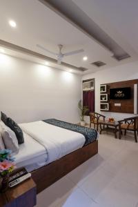 ニューデリーにあるHotel Krone Plaza Near IGI Airportの大きなベッドとテーブルのある寝室