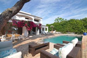 a villa with a swimming pool and a patio at Casa Quarenta Garrão in Quinta do Lago