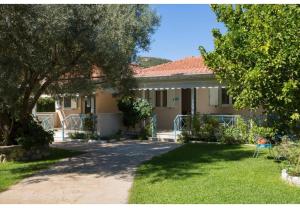 a house with a tree in the yard at Aelia House - Helios in Lefkada Town