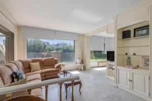 a living room with a couch and a large window at Villa Masnou in El Carrer del Canonge