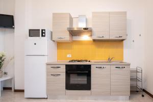 a kitchen with a white refrigerator and a stove at Il grappolo monolocale in Sirmione
