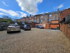 two cars parked in a parking lot in front of a building at The Albert Hotel in Gloucestershire