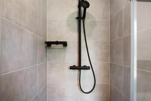 a shower with a shower head in a bathroom at Müritzblick in Vipperow +19 photos