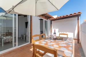 a dining room with a table and an umbrella at Casa vista golf in Caleta De Fuste