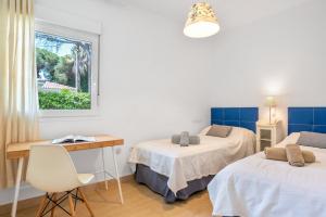 Habitación con 2 camas, escritorio y ventana. en Villa El Cenador - Solo Familias, en Roche 21 fotos más