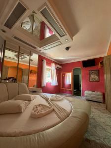 Cama grande en habitación con paredes rojas en Flats Ponte Pênsil, en São Vicente