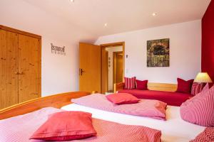 a bedroom with two beds with red pillows at Ferienwohnung Hahn in Weißensberg