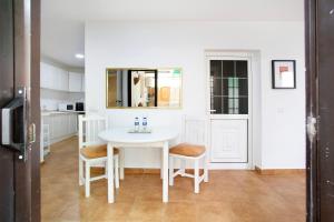 a white dining room with a table and chairs at Minipiso Tejina de Isora in Guía de Isora