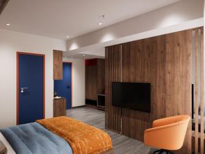 a bedroom with a bed and a television on a wall at Zone by The Park New Market Kolkata in Kolkata