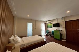 a hotel room with two beds and a television at Norn-Nanta House in Chiang Mai