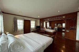 a bedroom with a large bed and a living room at Norn-Nanta House in Chiang Mai