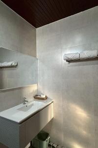 a white bathroom with a sink and a mirror at Norn-Nanta House in Chiang Mai